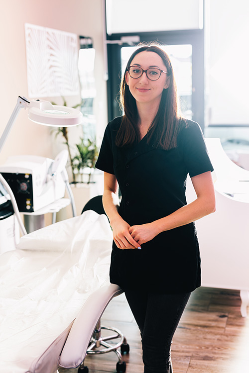 aesthetics nurse standing and smiling in her practice